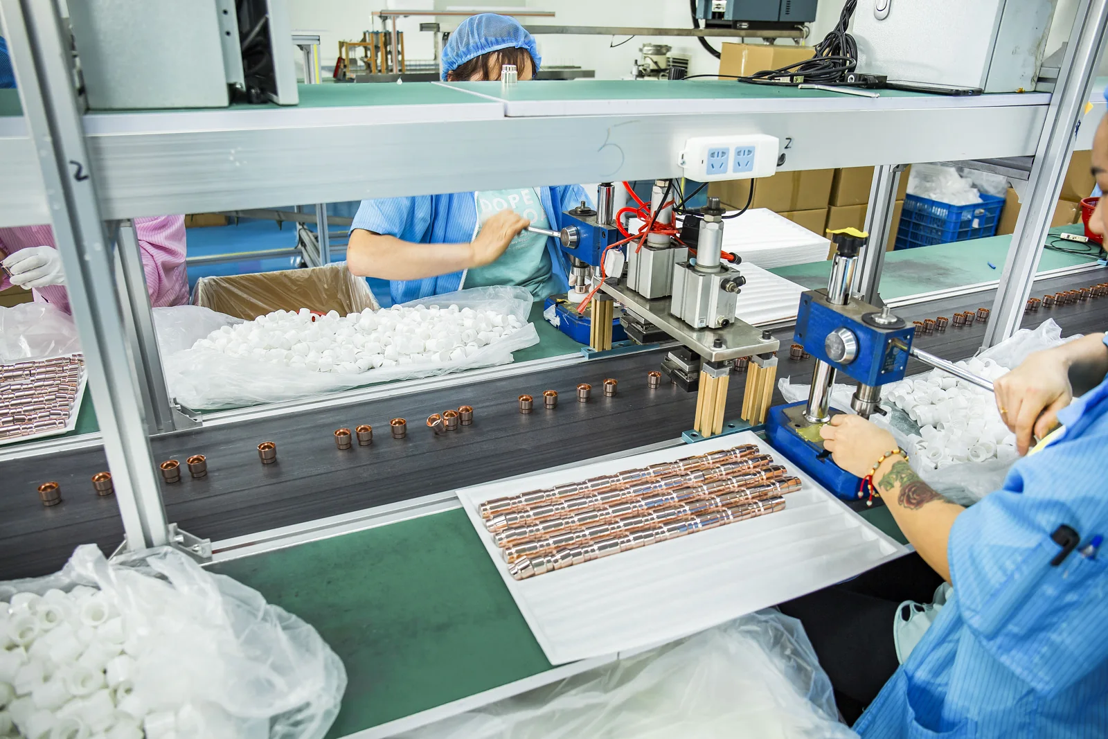 Operator's hands positioning a packaging component at an assembly fixture