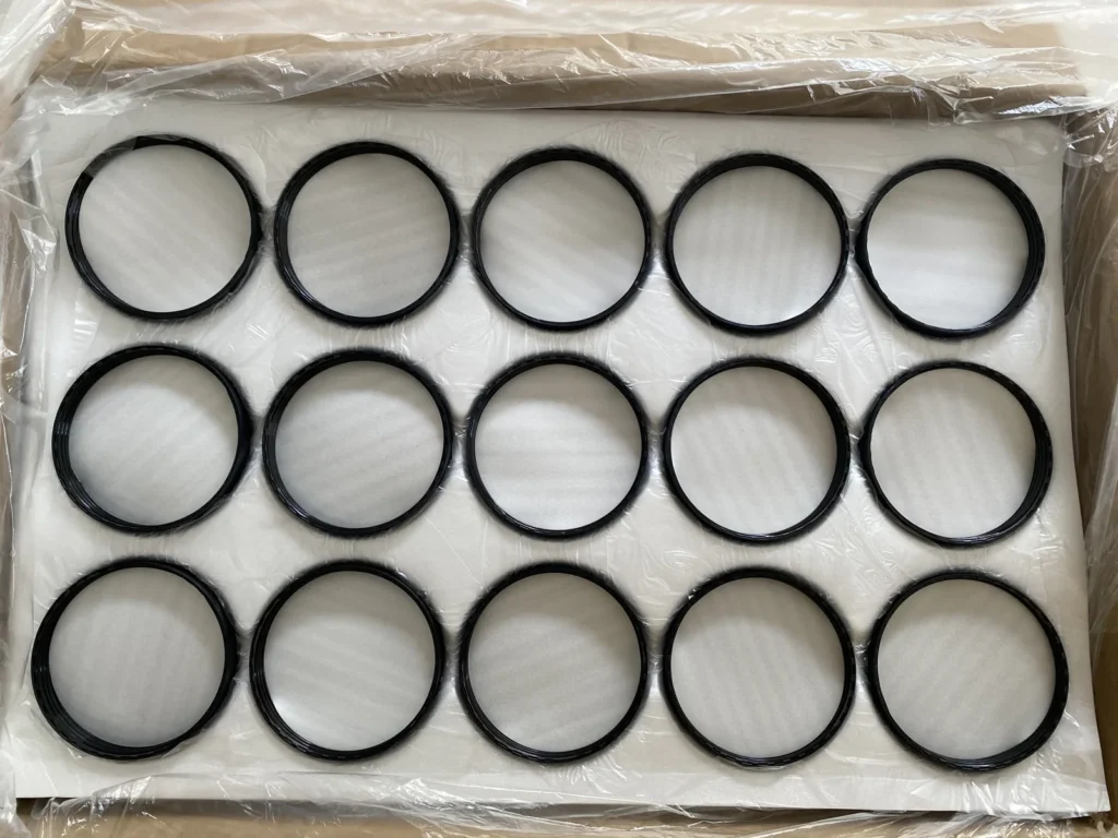 Black ring-shaped packaging components arranged in rows