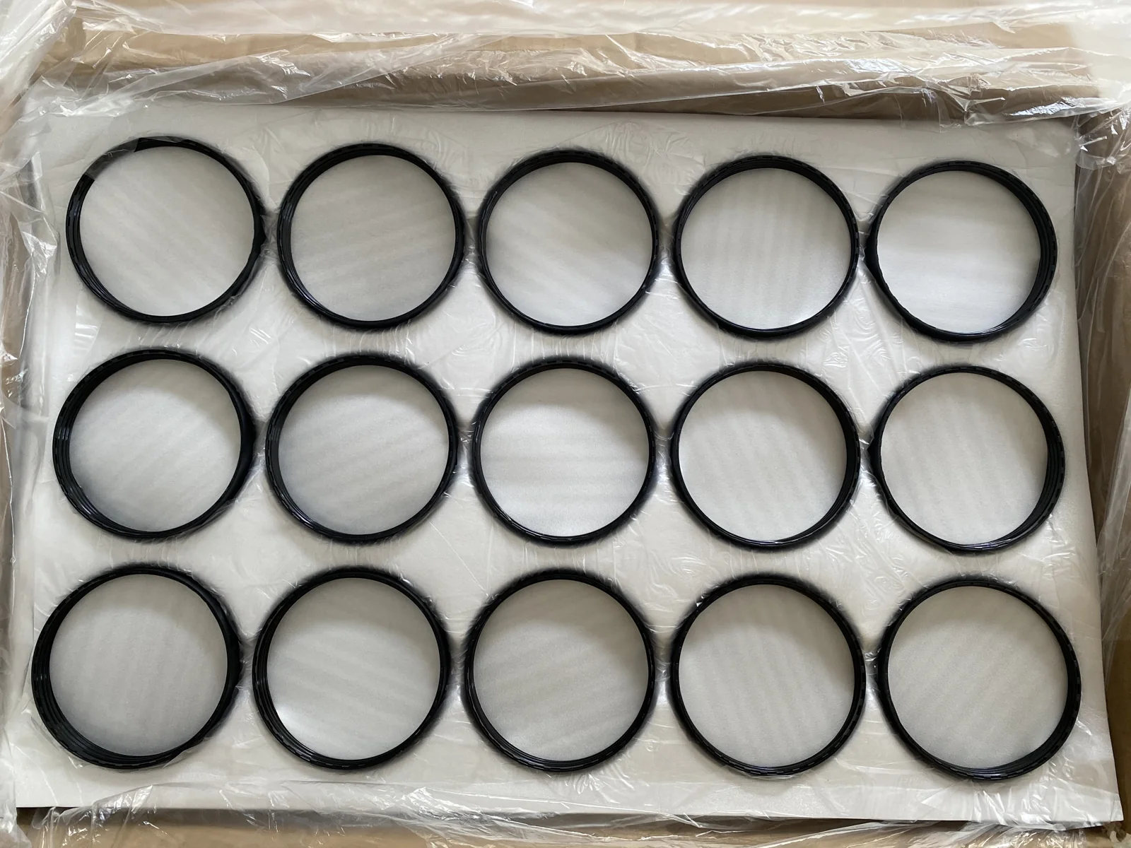 Black ring-shaped packaging components arranged in rows