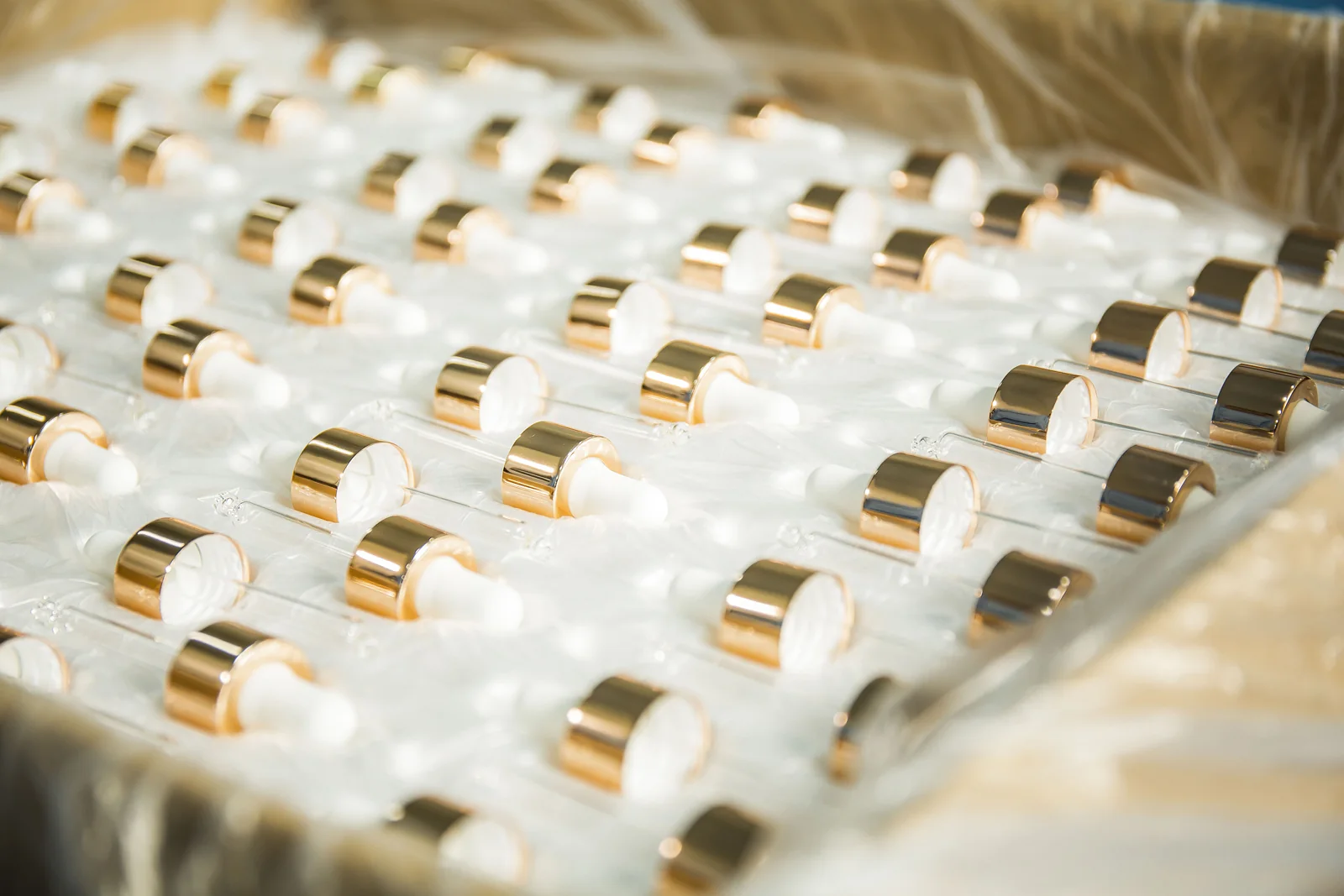 Close-up of gold-finish cosmetic packaging collars