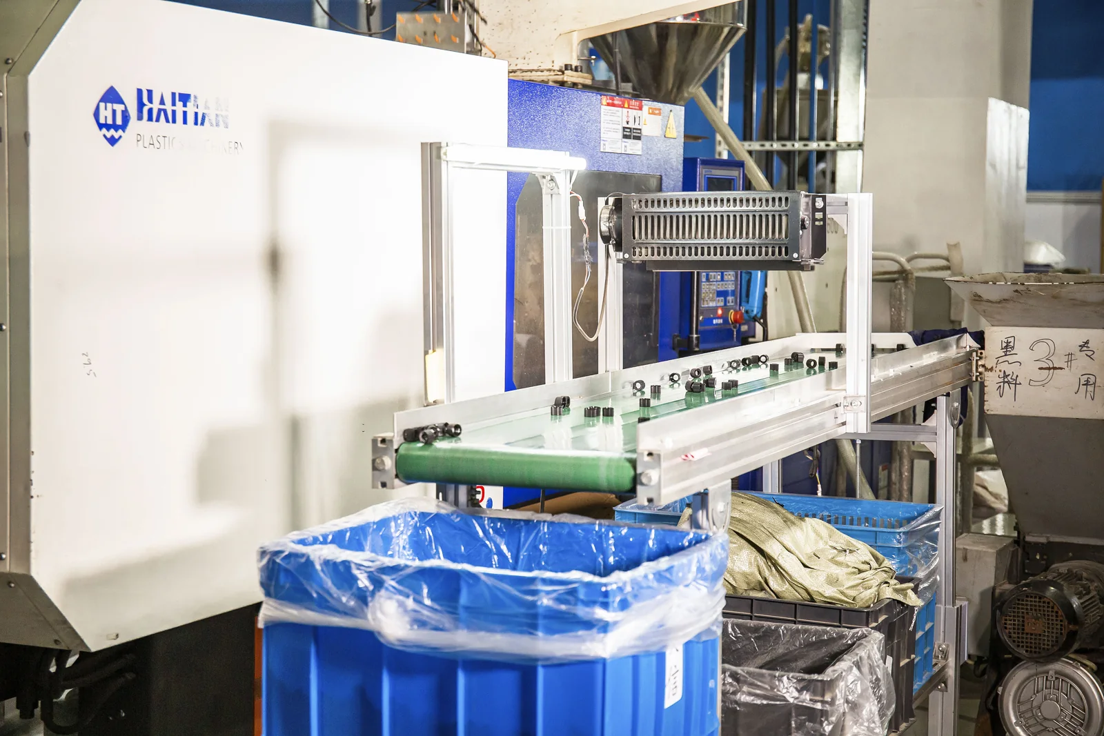 Injection molding machine and conveyor in the production area
