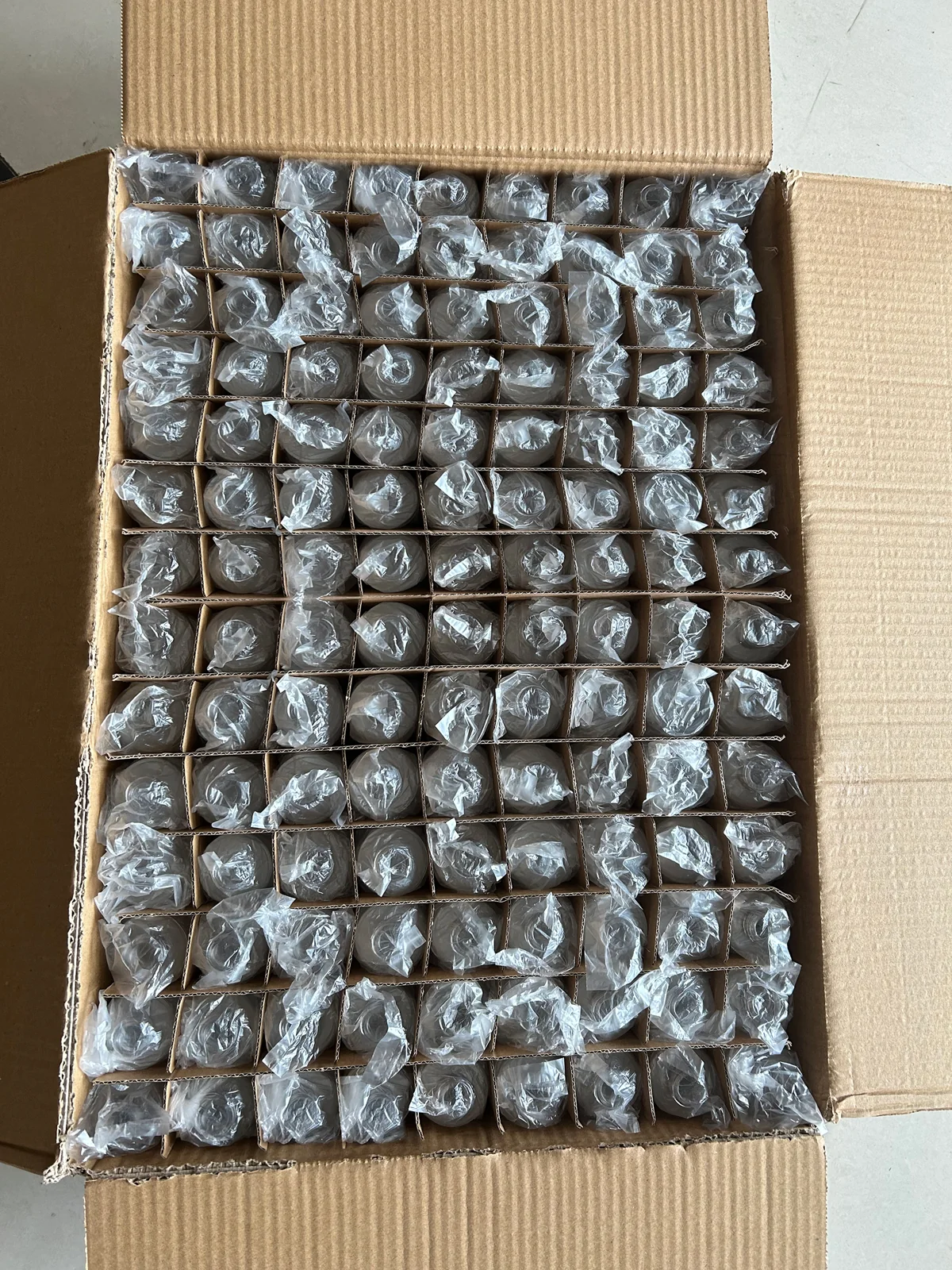 Cosmetic containers separated by protective packaging inside a carton