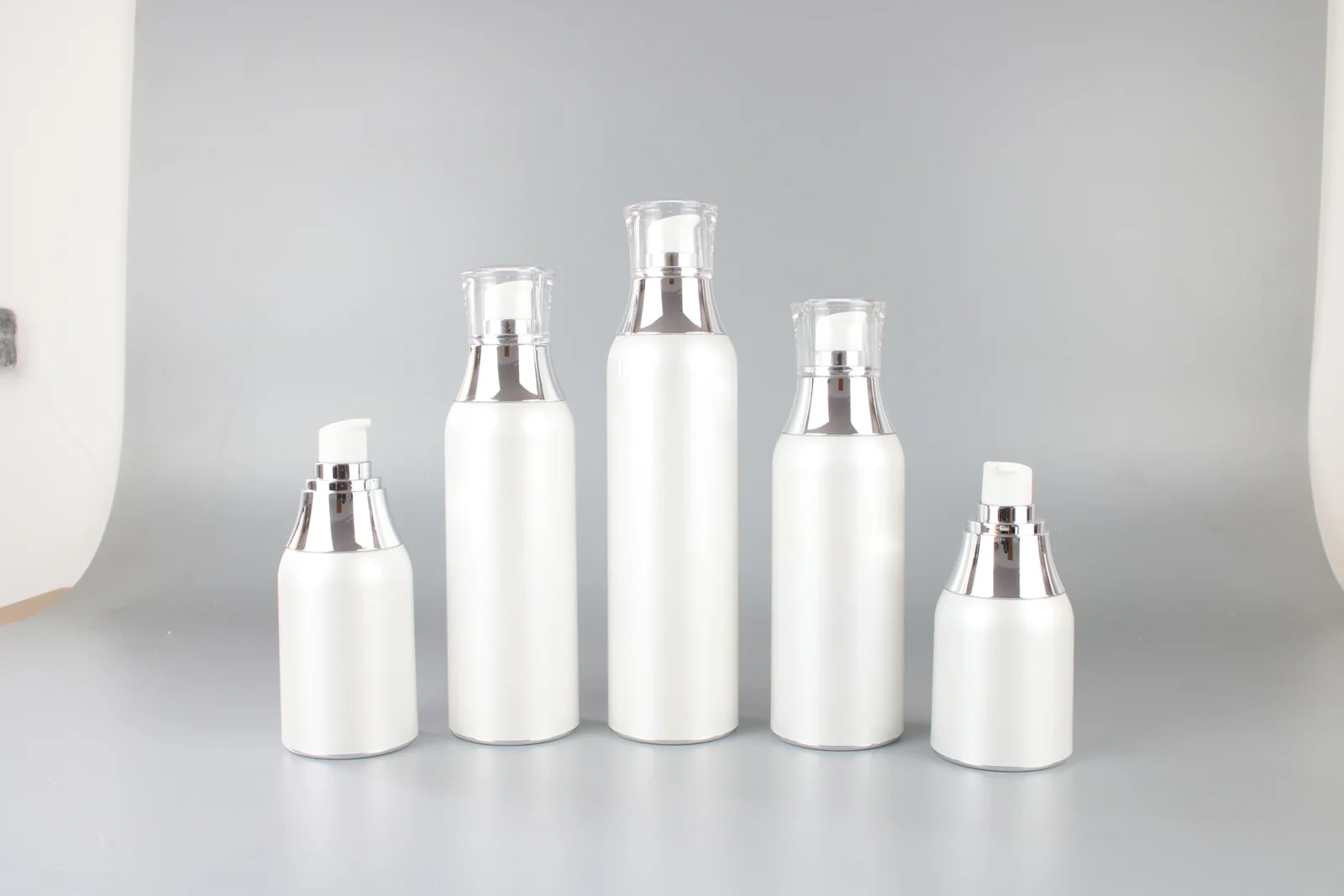White cosmetic pump bottles and jars arranged together